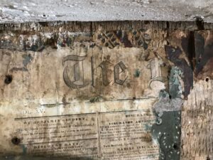 A worn and torn newspaper with the word "the" visible